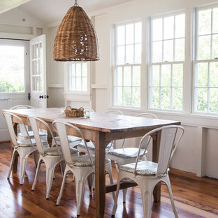 Modelo de comedor costero, de tamaño medio, con paredes blancas y suelo de madera en tonos medios