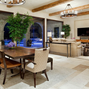 Immagine di una sala da pranzo aperta verso il soggiorno mediterranea con pareti beige e pavimento beige