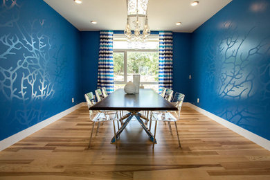 Inspiration for a large modern medium tone wood floor and brown floor enclosed dining room remodel in Austin with blue walls and no fireplace