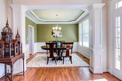 Inspiration for a transitional medium tone wood floor dining room remodel in Raleigh with green walls