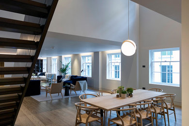 Photo of a large contemporary open plan dining room in London with grey walls and light hardwood flooring.