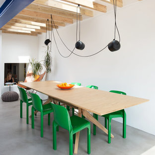 Photo of a scandi dining room in London with white walls, concrete flooring, no fireplace and grey floors.
