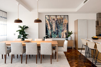 Exemple d'une grande salle à manger ouverte sur le salon tendance avec un mur blanc, un sol en bois brun et un sol marron.