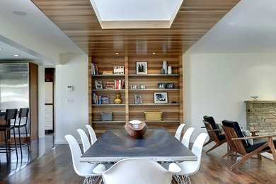 Diseño de comedor contemporáneo abierto con paredes blancas y suelo de madera en tonos medios