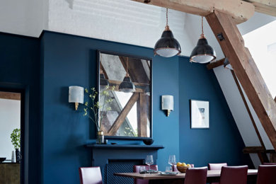 Photo of a large industrial open plan dining room in London with blue walls, light hardwood flooring and beige floors.