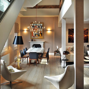 Ispirazione per una sala da pranzo aperta verso il soggiorno minimal di medie dimensioni con pareti beige, camino classico e parquet chiaro