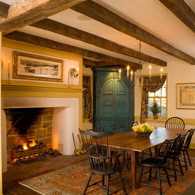 Example of a farmhouse dark wood floor enclosed dining room design in Philadelphia with beige walls and a standard fireplace