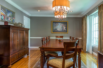 Enclosed dining room - large traditional medium tone wood floor and brown floor enclosed dining room idea in New York with gray walls and no fireplace
