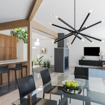 Statement Black Chandelier Above a Glass Top Dining Room Table