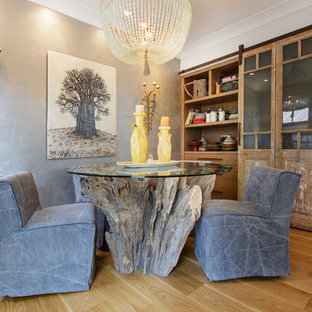 Example of an eclectic light wood floor and beige floor dining room design in Other with gray walls