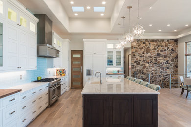 Example of a huge transitional medium tone wood floor and multicolored floor eat-in kitchen design in Las Vegas