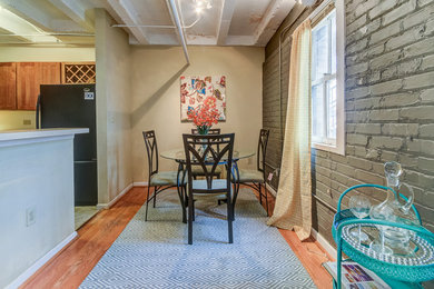 Cette photo montre une petite salle à manger ouverte sur la cuisine éclectique avec un mur gris.