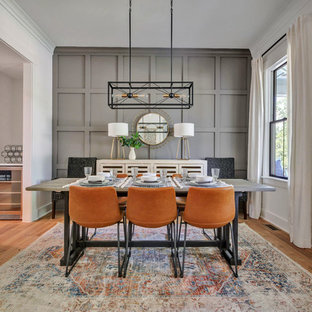 Immagine di una sala da pranzo country chiusa con pareti grigie, parquet chiaro e nessun camino