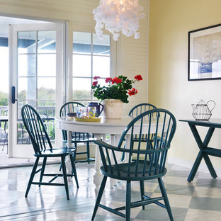 Modelo de comedor costero con paredes amarillas y suelo de madera pintada