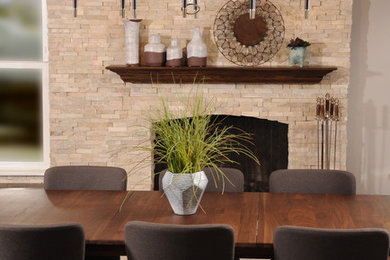 Immagine di una sala da pranzo classica di medie dimensioni con pareti grigie, pavimento in legno massello medio e cornice del camino in mattoni