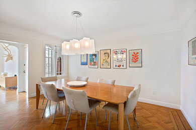 Example of a mid-sized trendy medium tone wood floor and brown floor enclosed dining room design in San Francisco with white walls and no fireplace