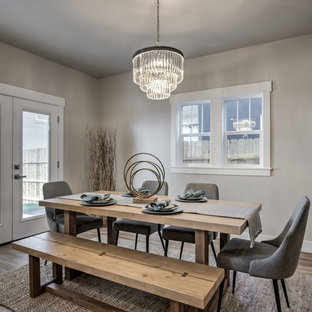 Modelo de comedor de cocina de estilo americano, de tamaño medio, con paredes grises, suelo laminado y suelo marrón