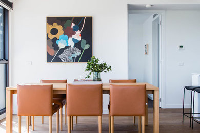 This is an example of a small contemporary dining room in Melbourne with laminate floors.