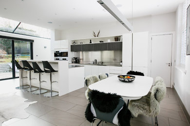 Contemporary kitchen/dining room in Surrey with white walls.