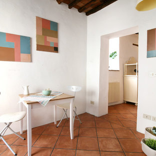 Foto di una sala da pranzo mediterranea con pareti bianche, pavimento in terracotta e pavimento arancione