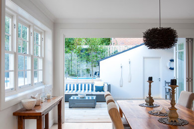 Ejemplo de comedor minimalista de tamaño medio con paredes blancas y suelo de madera clara