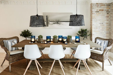 Inspiration pour une salle à manger ouverte sur la cuisine marine de taille moyenne avec un mur blanc et un sol en travertin.