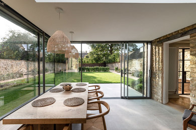 Immagine di una sala da pranzo aperta verso il soggiorno minimal di medie dimensioni con pavimento in gres porcellanato e pavimento grigio
