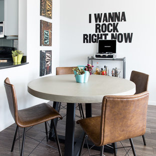 Immagine di una piccola sala da pranzo aperta verso la cucina moderna con pareti grigie e pavimento in laminato