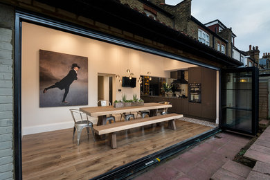ロンドンにある広いコンテンポラリースタイルのおしゃれなダイニングキッチン (白い壁、濃色無垢フローリング、茶色い床) の写真
