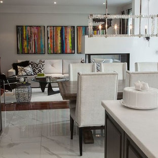 Esempio di una piccola sala da pranzo aperta verso la cucina contemporanea con pareti bianche, pavimento in marmo e camino bifacciale
