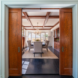 Modelo de comedor casetón y boiserie, de estilo americano, grande, cerrado y boiserie, con paredes grises, suelo de madera oscura, chimenea tradicional, marco de chimenea de baldosas y/o azulejos, suelo negro y boiserie
