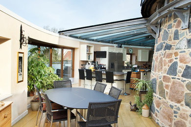 Photo of a contemporary open plan dining room in Channel Islands with beige walls and light hardwood flooring.