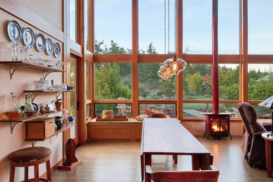 Cette image montre une salle à manger ouverte sur le salon design de taille moyenne avec un poêle à bois, un mur blanc et un sol en bois brun.
