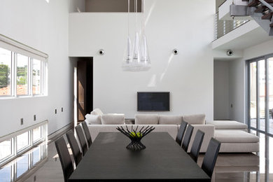 Ejemplo de comedor minimalista grande abierto con paredes blancas y suelo de cemento