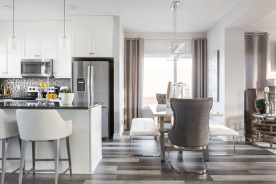 This is an example of a medium sized contemporary kitchen/dining room in Edmonton with laminate floors, multi-coloured floors, grey walls and no fireplace.