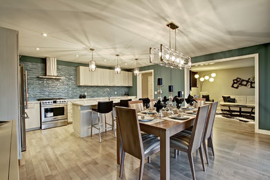 На фото: кухня-столовая среднего размера в стиле неоклассика (современная классика) с зелеными стенами и светлым паркетным полом без камина с