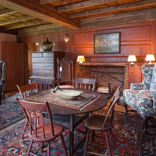 Foto di una sala da pranzo country con pareti rosse e camino classico