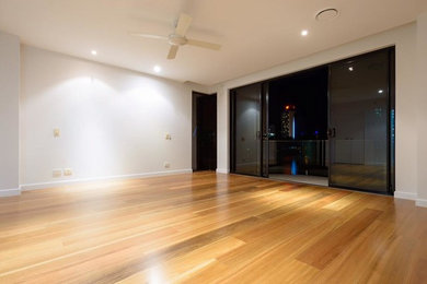 Large trendy medium tone wood floor great room photo in Brisbane with white walls