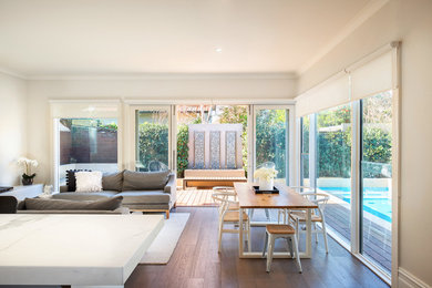 Idées déco pour une grande salle à manger contemporaine avec un mur blanc, parquet foncé et un sol marron.