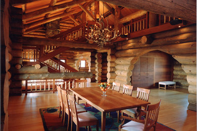Idée de décoration pour une grande salle à manger ouverte sur la cuisine chalet avec un mur marron et un sol en bois brun.