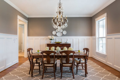 Mid-sized elegant medium tone wood floor enclosed dining room photo in Houston with beige walls