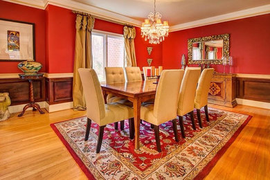 Idée de décoration pour une grande salle à manger ouverte sur la cuisine tradition avec un mur rouge et parquet clair.