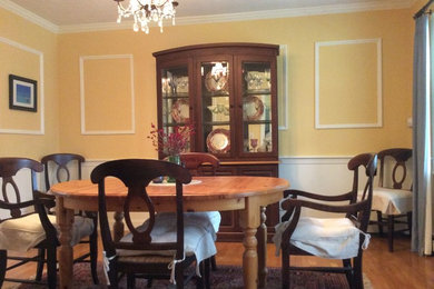 Foto de comedor clásico de tamaño medio cerrado sin chimenea con paredes amarillas y suelo de madera en tonos medios