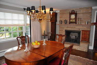 Large elegant medium tone wood floor and brown floor enclosed dining room photo in Philadelphia with gray walls, a standard fireplace and a brick fireplace