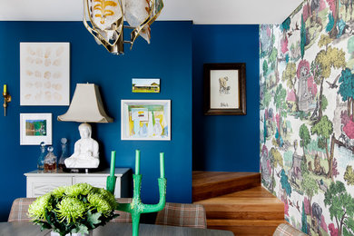 Стильный дизайн: столовая с синими стенами, паркетным полом среднего тона и коричневым полом - последний тренд