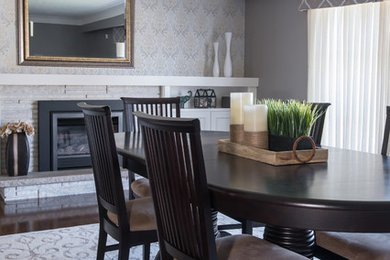 Example of a transitional dark wood floor dining room design in Toronto with gray walls, a standard fireplace and a brick fireplace