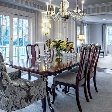 Transitional modern dining room has neutral palette grey stripe wallpaper.