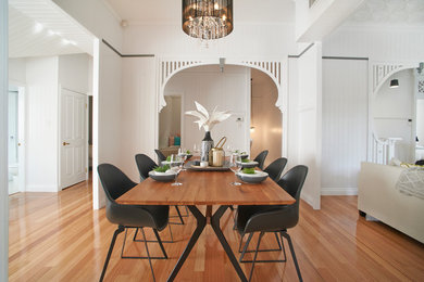 Cette photo montre une salle à manger moderne de taille moyenne avec un mur blanc, un sol en bois brun et un sol marron.