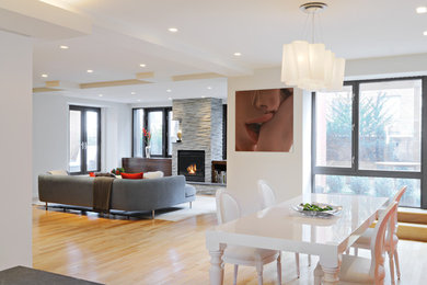 Cette photo montre une grande salle à manger ouverte sur le salon tendance avec un mur blanc, parquet clair et un sol marron.
