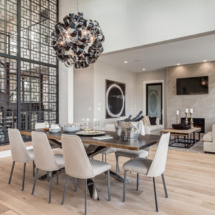 Idées déco pour une salle à manger ouverte sur le salon contemporaine de taille moyenne avec un sol en bois clair, un mur blanc, une cheminée standard, un manteau de cheminée en carrelage et un sol beige.